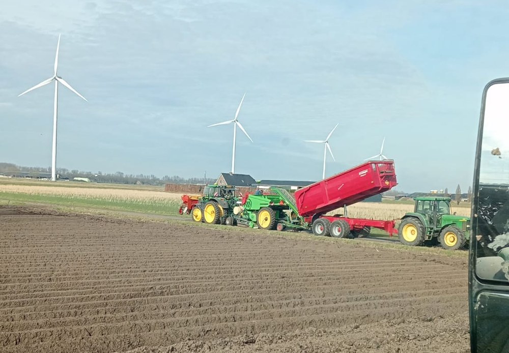 Tractoren met pootmachine en kipwagen tijdens het pootseizoen